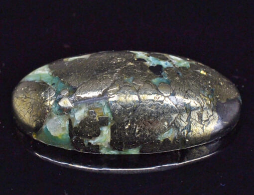 An oval shaped turquoise stone on a black surface.