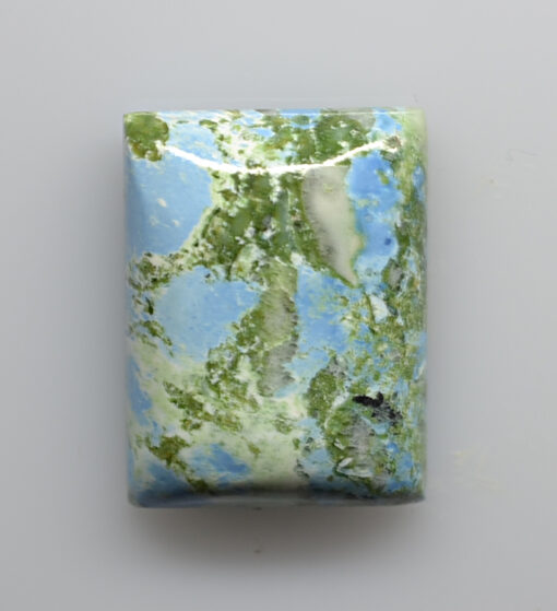 A piece of blue and green marble on a white surface.