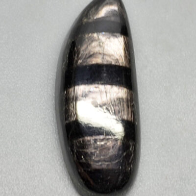 A black and white striped stone on a white surface.