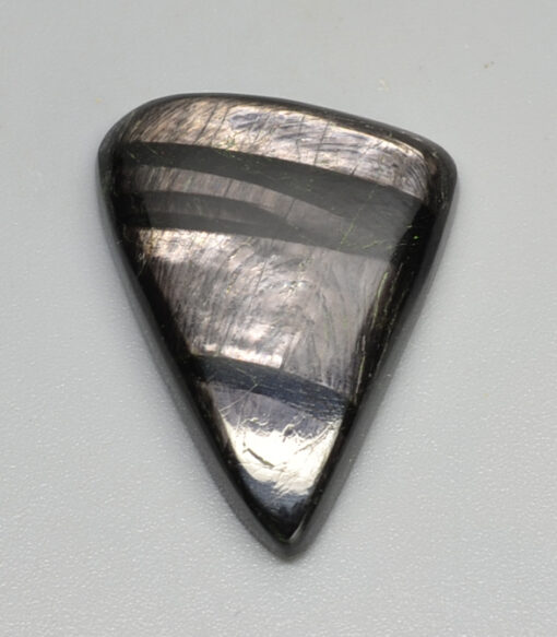 A black labradorite triangle on a white surface.