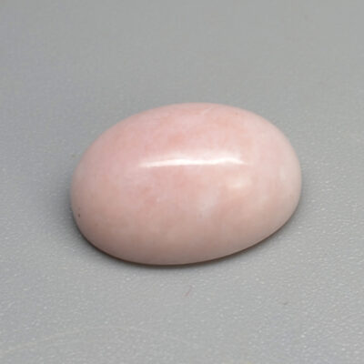 A pink stone on a grey surface.