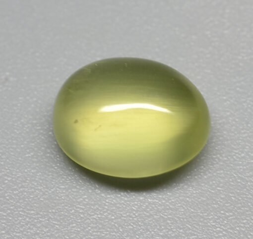 A yellow oval object on a white surface.