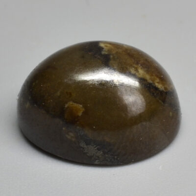 A brown stone sphere on a white surface.