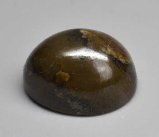 A brown stone sphere on a white surface.