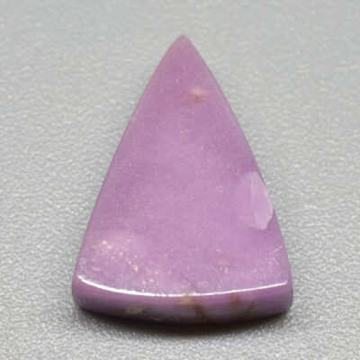A Phosphosiderite 2.61 ct Cabochon Superb Color Trillion 12.20 x 9.00 x 3.00 mm Peru on a grey surface.