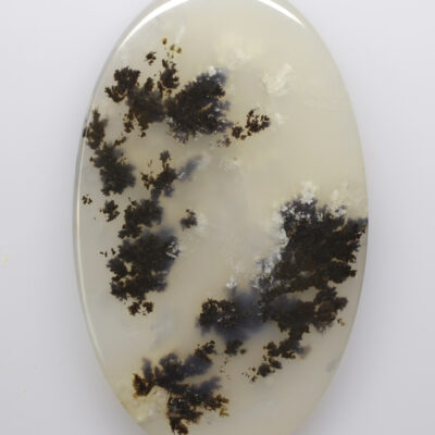 A white and black agate oval on a white surface.