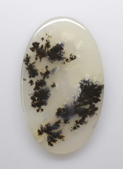 A white and black agate oval on a white surface.