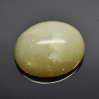 A yellow jade stone on a black surface.