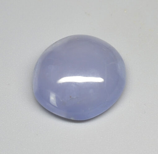 A blue jade stone on a white surface.