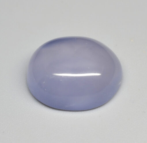 A purple jade stone on a white surface.