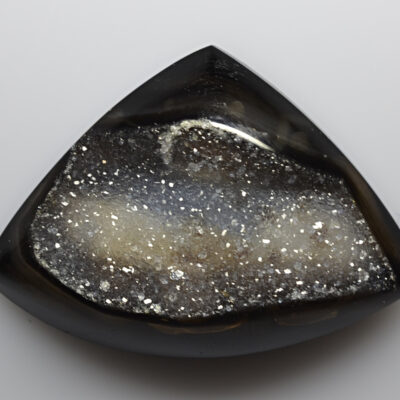 A black and white druzy on a white surface.