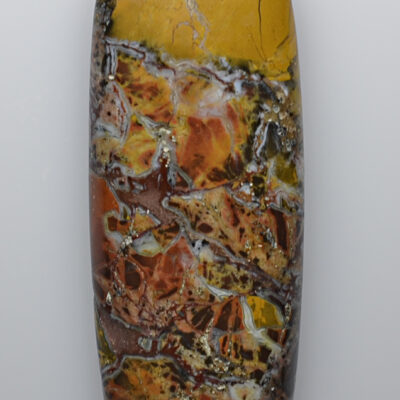 A yellow and brown piece of jasper on a white surface.