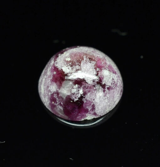 A purple stone on a black surface.