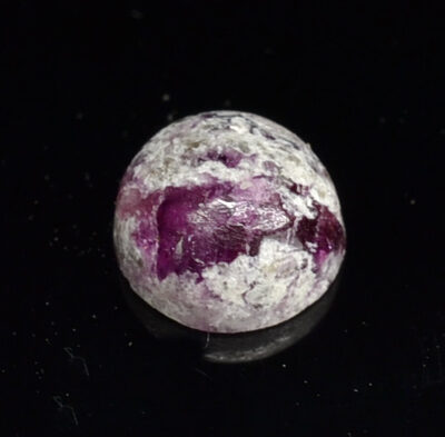 A pink stone with white specks on it.