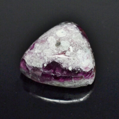 A purple stone on a black surface.