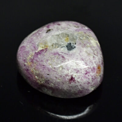 A purple stone on a black surface.
