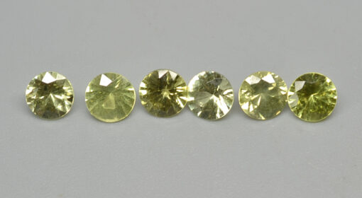 A group of yellow sapphires on a white surface.