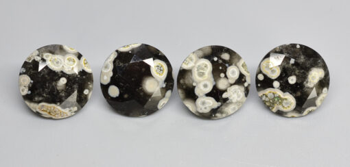 Four oval shaped black and white apatite cabochons.