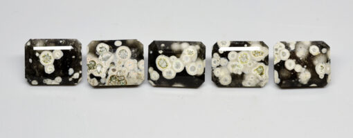 A group of black and white stones with white spots on them.