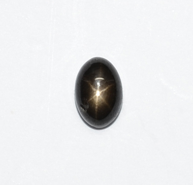 A black oval object with a light reflecting off the surface.