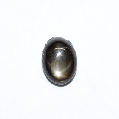 An oval shaped black stone on a white surface.