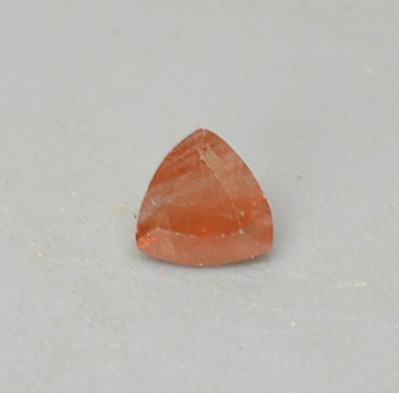 An orange stone in a triangular shape.