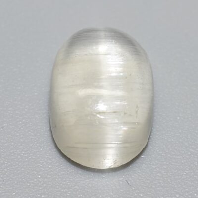 An oval shaped white quartz on a white surface.