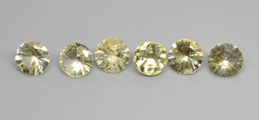 A group of yellow sapphires on a white surface.
