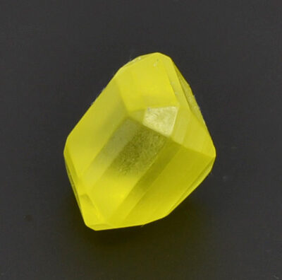 A piece of yellow glass on a black surface.