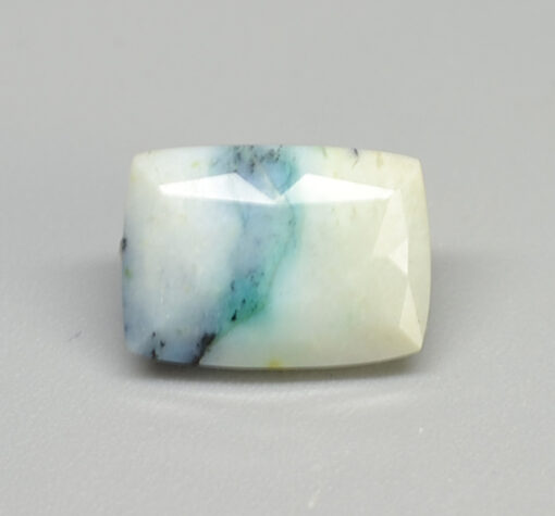 A white and blue apatite stone on a white surface.